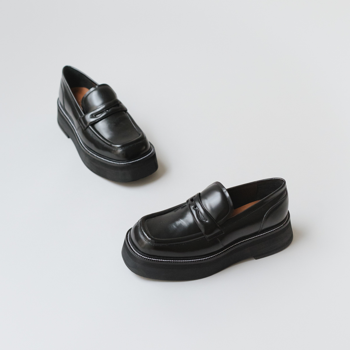 Platform loafers in black glazed leather | DAFFY