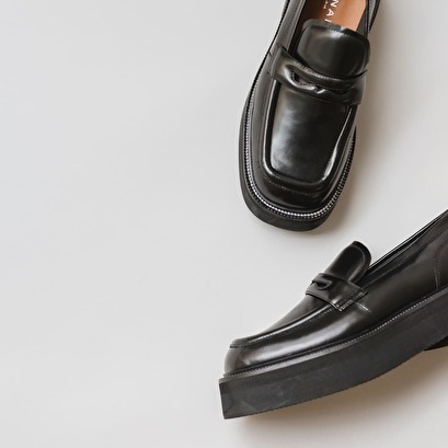 Platform loafers in black glazed leather | daffy
