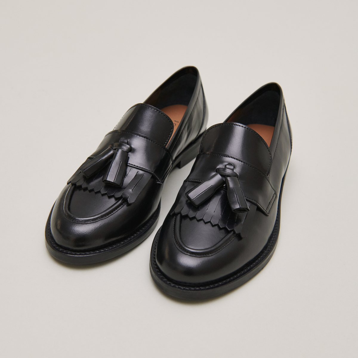 Flat heel loafers with tassels in black leather | DIE