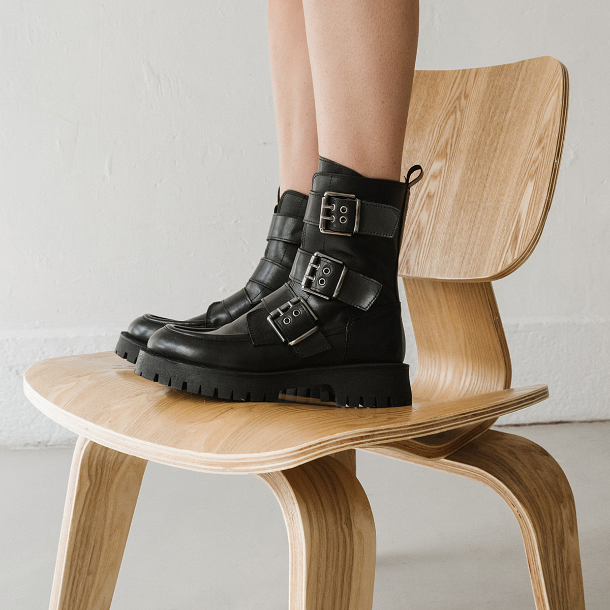 Boots with notched soles and straps in black leather | RUNNER