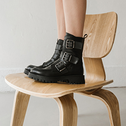 Boots with notched soles and straps in black leather | runner