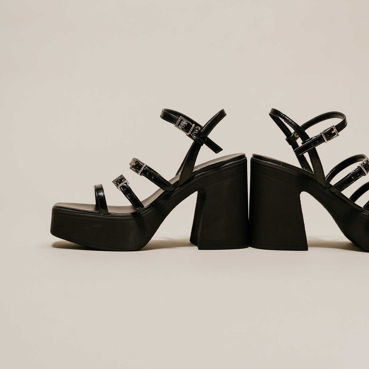 Sandals with straps and platforms in black pleated patent | PUZZLE