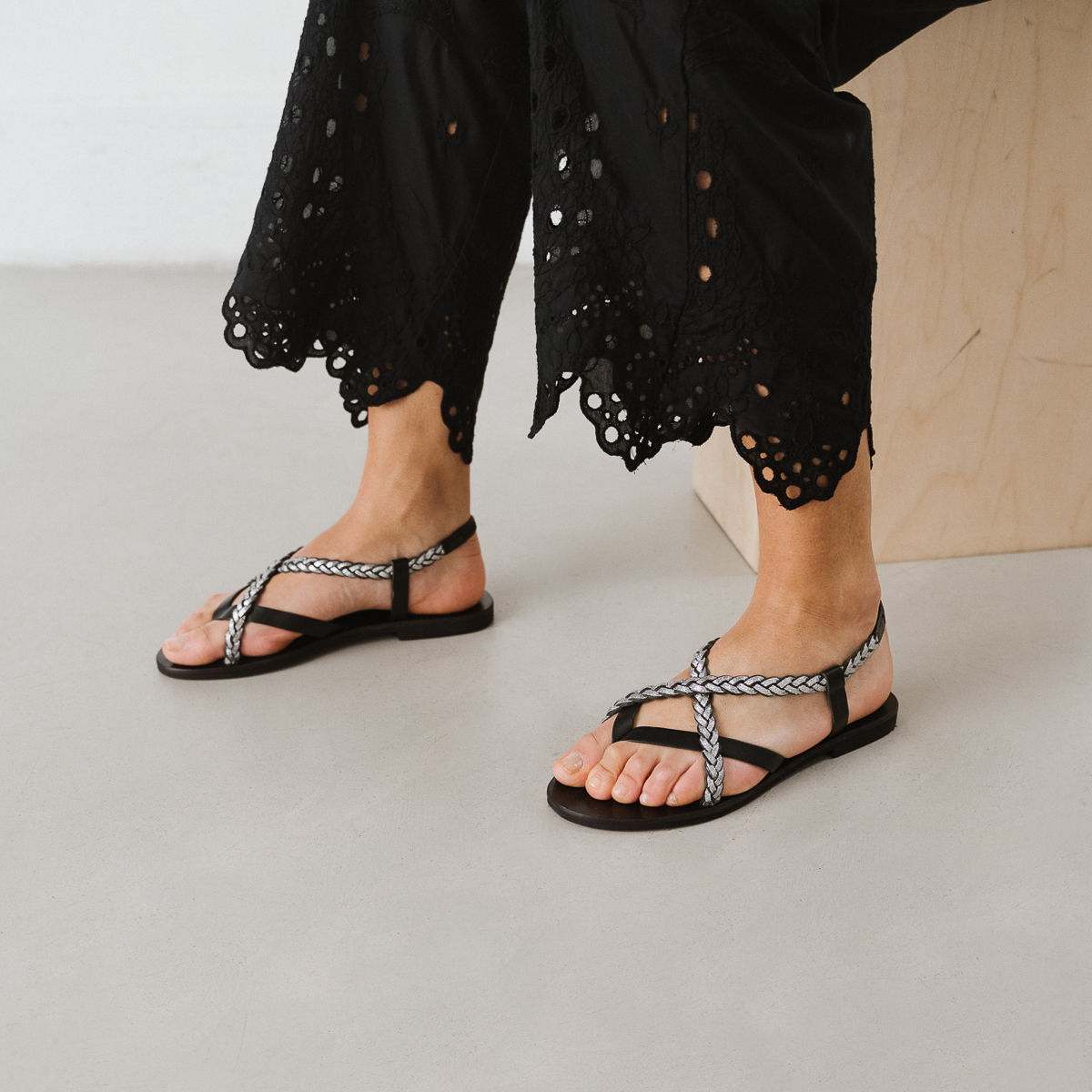 Sandals with braided straps in black and silver leather | WARREN