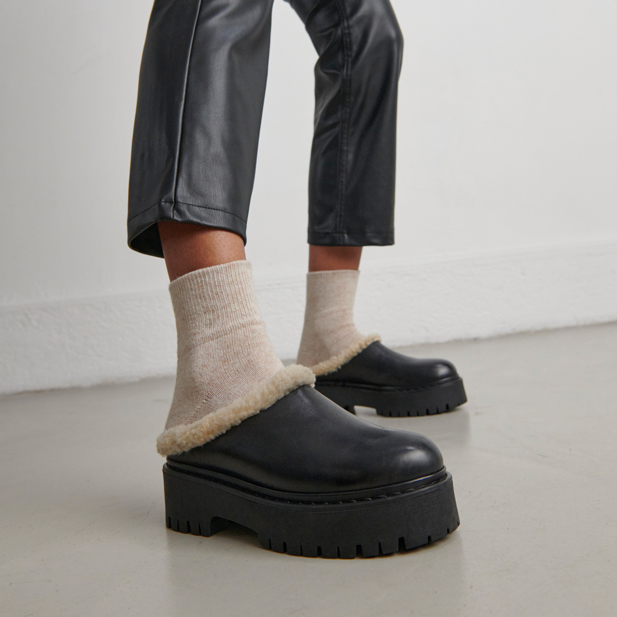 Round-toed mules with notched soles in black leather | RAYA