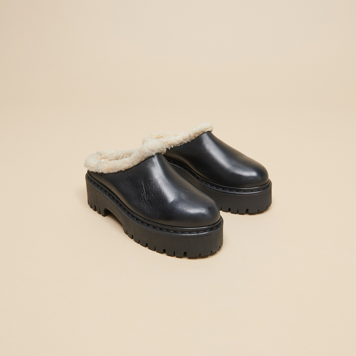 Round-toed mules with notched soles in black leather | RAYA