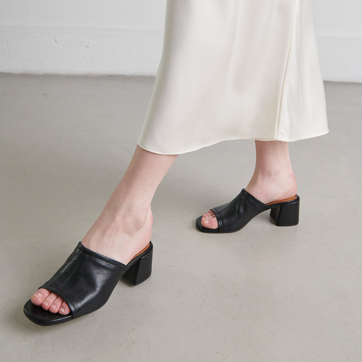 Mules with heels and open toes in black leather | BUTTERFLY