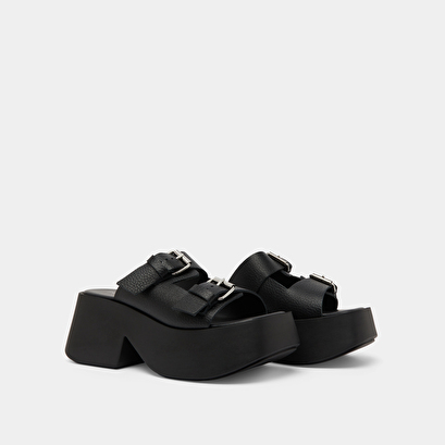 Mules with thick straps, buckles and open toes in black grained leather | ENOLA