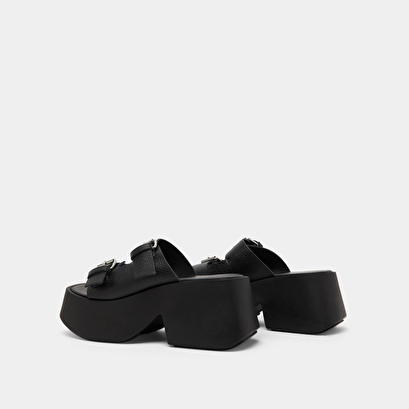 Mules with thick straps, buckles and open toes in black grained leather | ENOLA