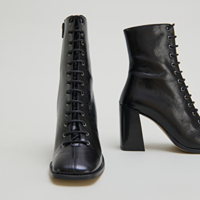 Bottines &agrave; talons lac&eacute;es in black distressed leather | vandelle