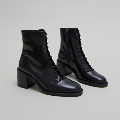 Boots &agrave; lacets et talons d&eacute;bordants in black leather | brindille
