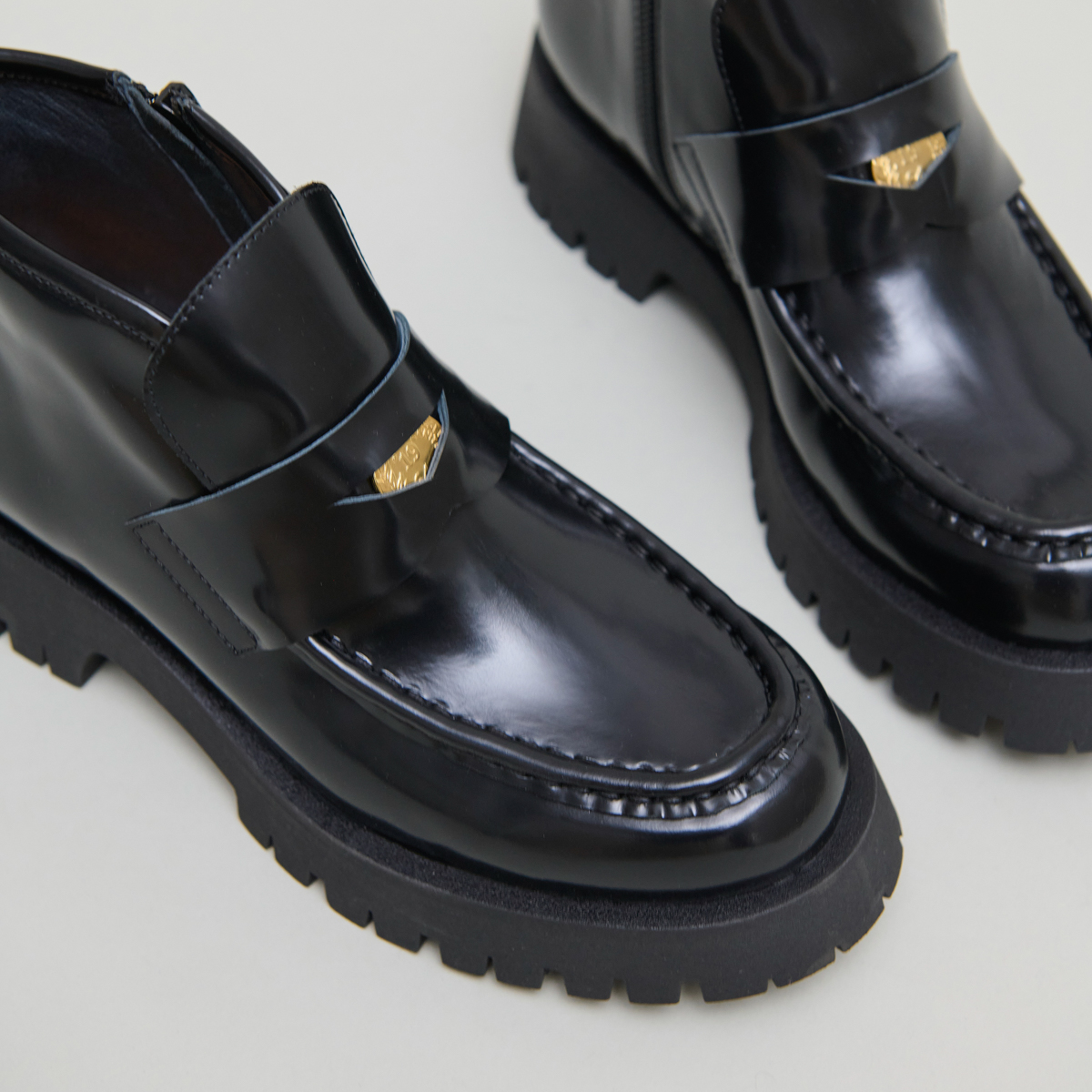 Boots à empiècements in black glazed leather | DESK