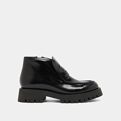 Boots &agrave; empi&egrave;cements in black glazed leather | desk