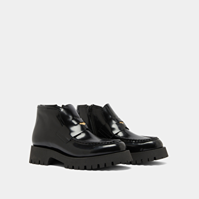Boots &agrave; empi&egrave;cements in black glazed leather | desk