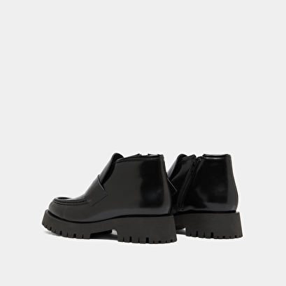 Boots &agrave; empi&egrave;cements in black glazed leather | desk