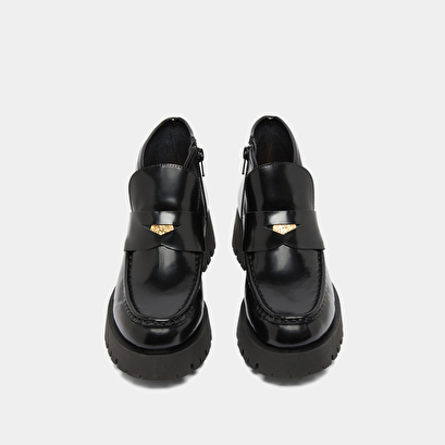 Boots &agrave; empi&egrave;cements in black glazed leather | desk