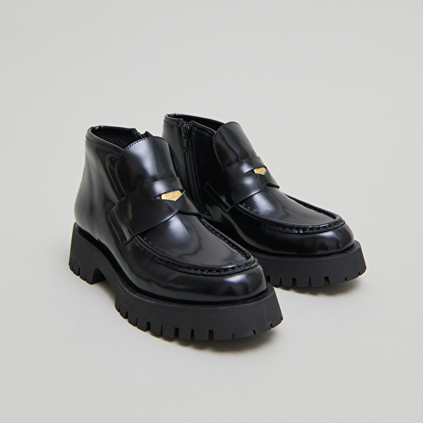 Boots à empiècements in black glazed leather | DESK