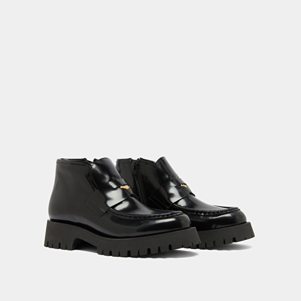 Boots à empiècements in black glazed leather | DESK