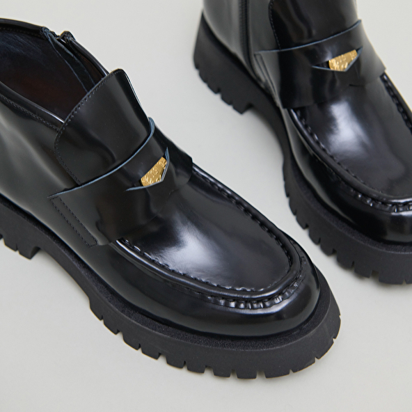 Boots à empiècements in black glazed leather | DESK