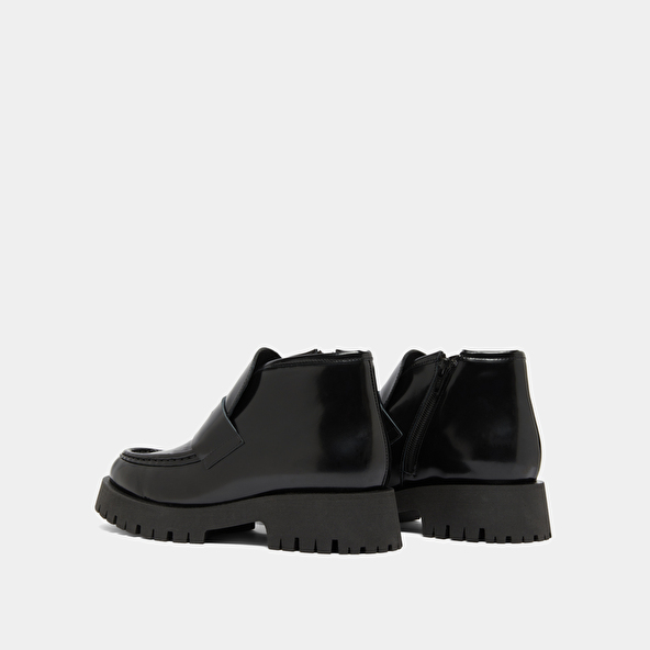 Boots à empiècements in black glazed leather | DESK