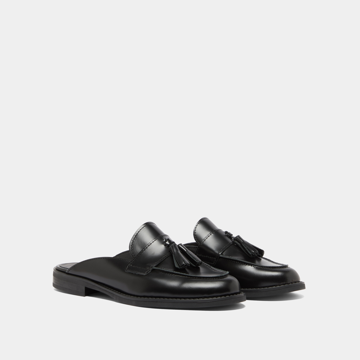 Loafers with tassels and open backs in black glazed leather | NATALY