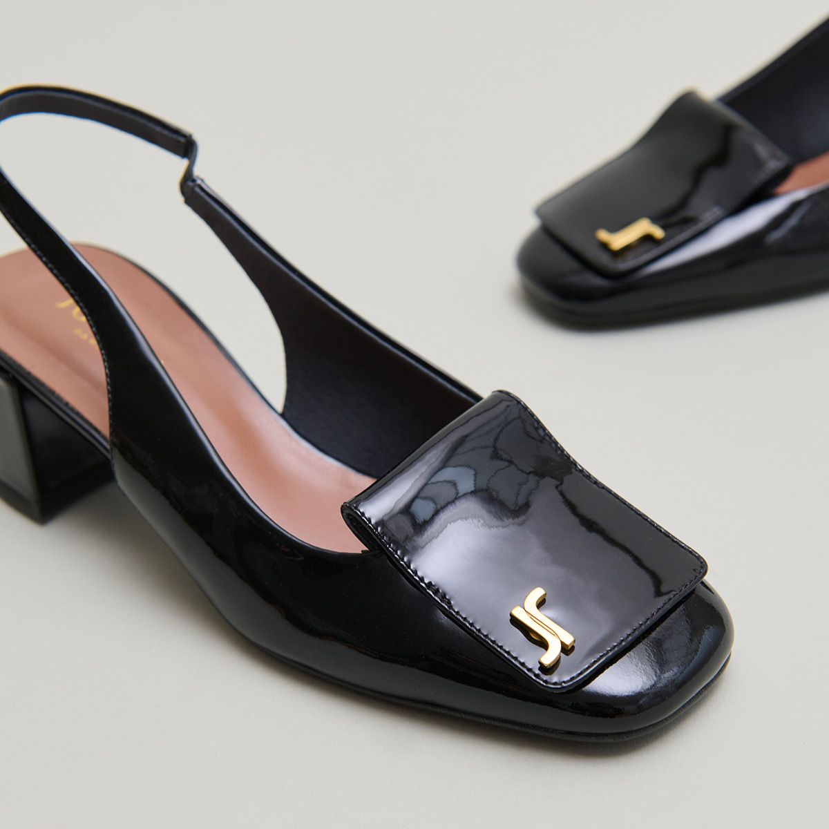 Monogrammed slingback pumps in black varnish | DAIKI