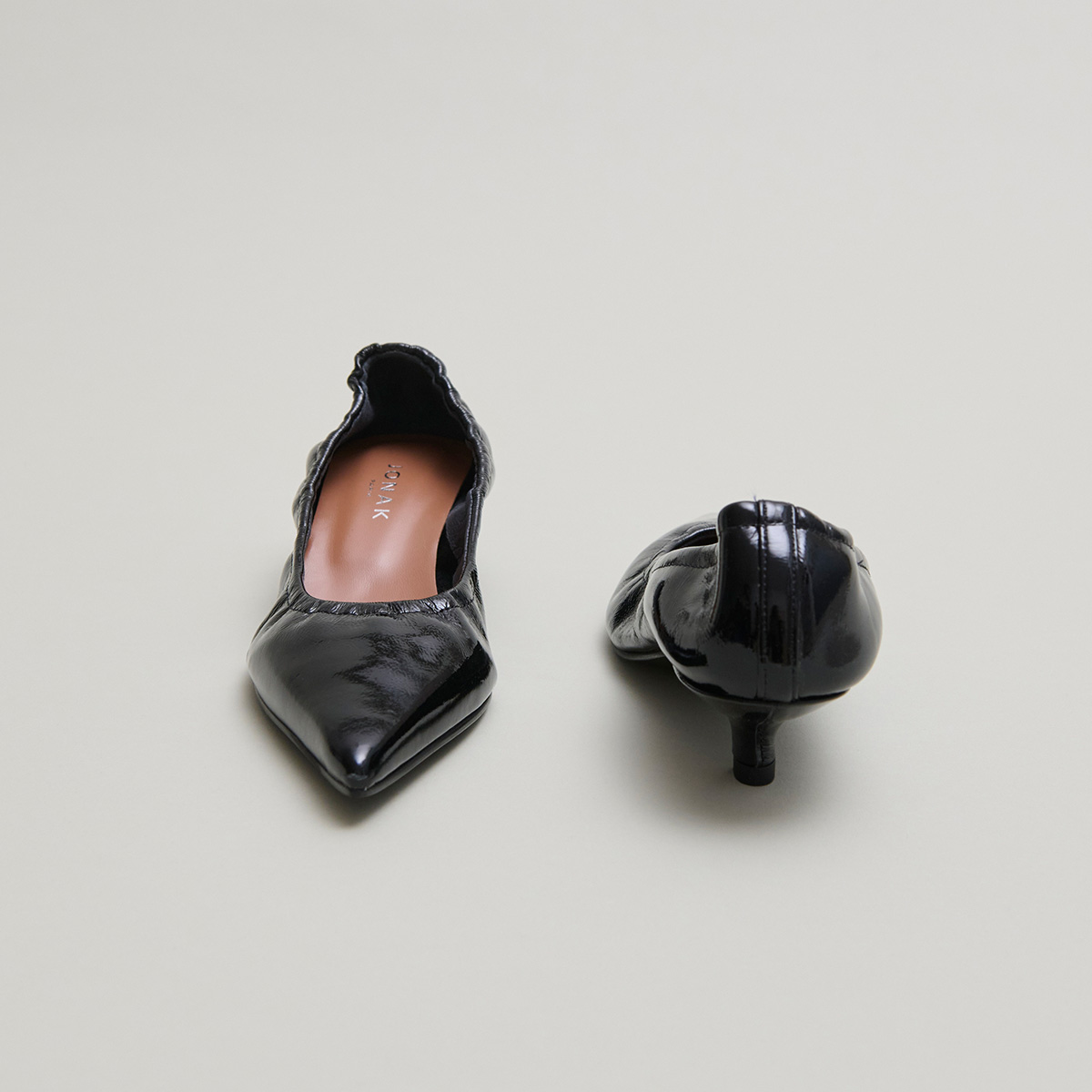Pointed-toe pumps in black pleated varnish | DOUA