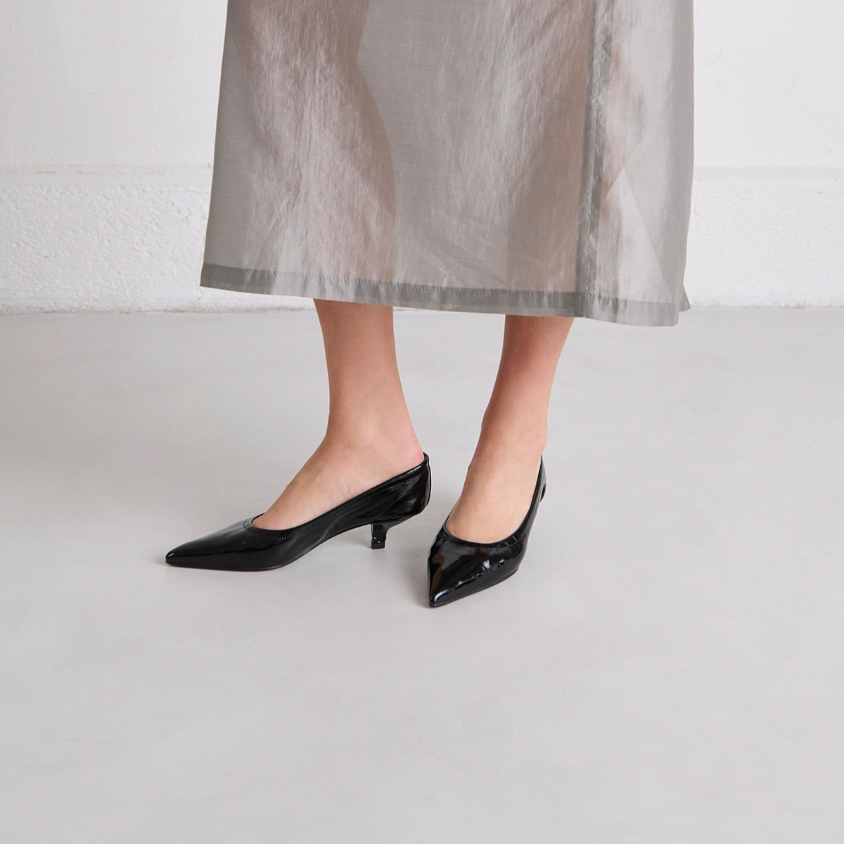 Pointed-toe pumps in black pleated varnish | DOUA