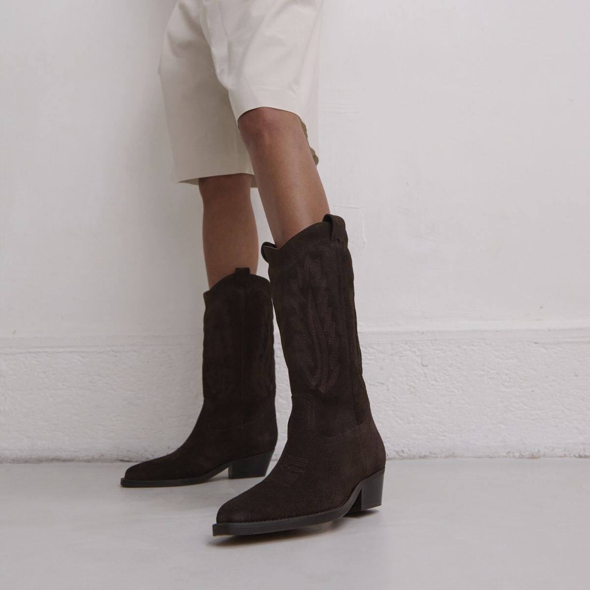 Pointed-toe boots with visible stitching in dark brown suede | DELEA