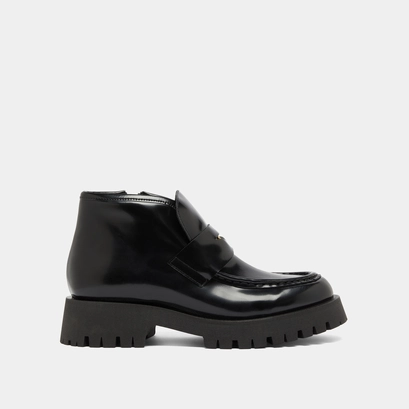 Boots &agrave; empi&egrave;cements in black glazed leather | desk