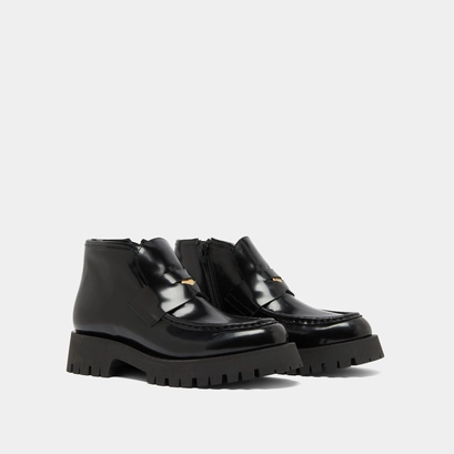 Boots &agrave; empi&egrave;cements in black glazed leather | desk