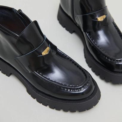 Boots &agrave; empi&egrave;cements in black glazed leather | desk