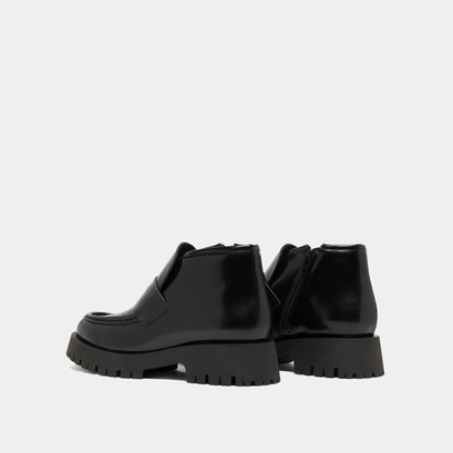 Boots &agrave; empi&egrave;cements in black glazed leather | desk