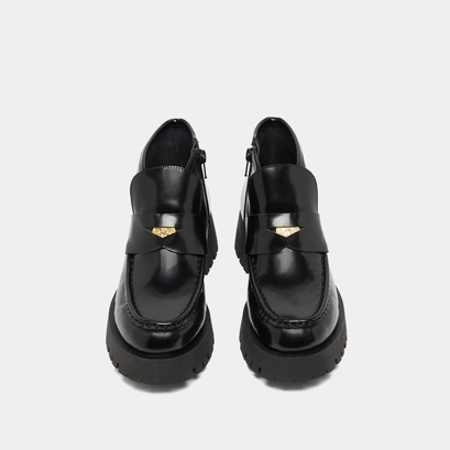 Boots &agrave; empi&egrave;cements in black glazed leather | desk