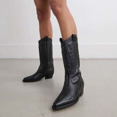 Pointed toe boots with exposed stitching in black grained leather | delea