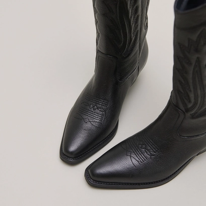 Pointed toe boots with exposed stitching in black grained leather | delea